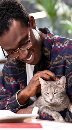 Happy man cuddling grey cat